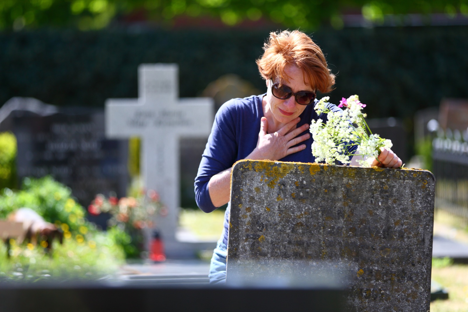 Женщина плачет на кладбище